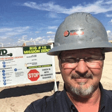 a man wearing a hard hat and glasses is standing in front of a sign that says rig # 10 mission zero