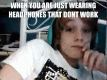 a young boy wearing headphones is sitting in front of a computer .