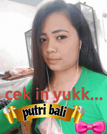 a woman wearing ear buds and a green sweater has a banner that says putri bali on it