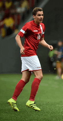 a soccer player wearing a red and white hummel jersey