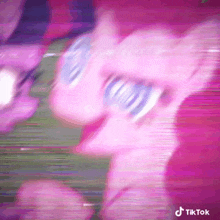 a close up of a pink pony wearing sunglasses and a pink background .