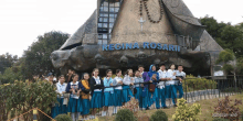 a group of children standing in front of a regina rosari building