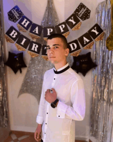 a man in front of a happy birthday banner