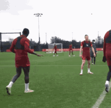 a group of soccer players are playing on a field and one of them is wearing a jersey that says ' liverpool '