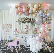 a table decorated with balloons and flowers for a birthday