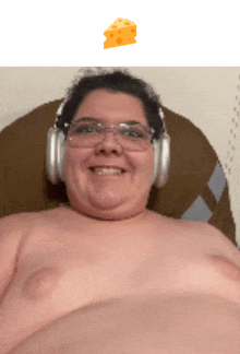 a shirtless man wearing headphones and glasses is smiling