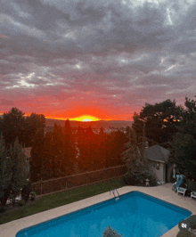 a pool with a sunset in the background