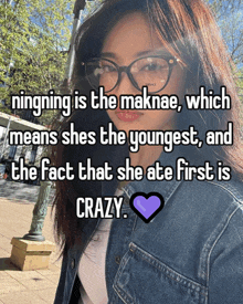 a woman wearing glasses and a denim jacket says ningning is the maknae which means she 's the youngest