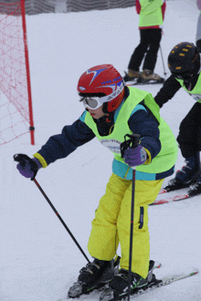 a young boy wearing a helmet with the number 7 on it is skiing