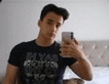 a young man is taking a selfie with his phone in front of a mirror .