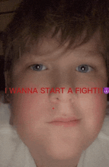 a close up of a boy 's face with the words " i wanna start a fight " written in red