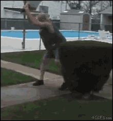 a man is standing in front of a pool with a 4gifs.com watermark on the bottom right