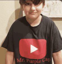 a boy wearing a black t-shirt that says mr. purple cap on it