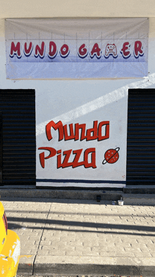 a sign on the side of a building says mundo pizza