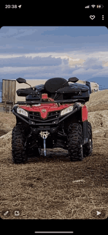 a red atv is parked on a dirt road