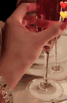 a woman holds a glass of wine in her hand