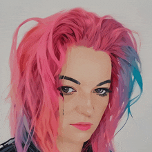 a woman with pink and blue hair has a tattoo on her forehead