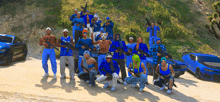 a group of people wearing blue plaid shirts and holding guns pose for a picture