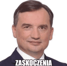 a man in a suit and tie is smiling with a sticker on his face that says zaskoczenia .