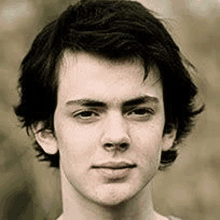 a close up of a young man 's face with dark hair .