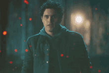 a man in a dark room with red lights coming out of his jacket