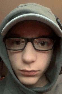 a young man wearing glasses and a hoodie