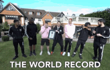 a group of men standing in front of a large house with the words " the world record " written below them