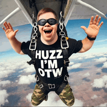 a man wearing a shirt that says huzz i 'm otw is jumping in the air