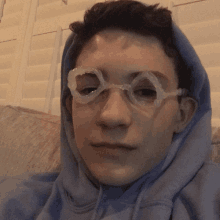 a boy wearing a blue hoodie and glasses