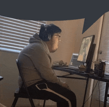 a man wearing headphones is sitting in front of a computer