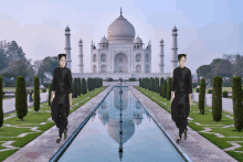 two men walking in front of the taj mahal