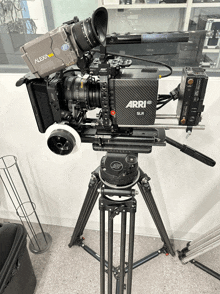 a camera on a tripod that says " arri " on it