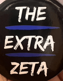 a person is holding a button that says the extra zeta