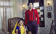 a man in a red shirt is standing next to a girl in a yellow dress