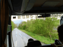 a view of a road from inside a bus with a sticker on the window that says 031 ts3 009 tsa