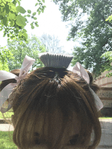 a person with a cupcake on top of their head with a sticker that says ' a ' on it