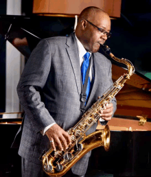 a man in a suit and tie plays a saxophone