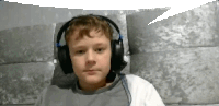 a young boy wearing headphones and a white shirt .