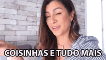 a woman is wearing hoop earrings and a striped shirt and says " coisinhas e tudo mais " .