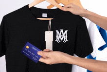 a person holding a credit card in front of a t-shirt