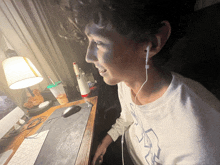 a man wearing ear buds is sitting at a desk