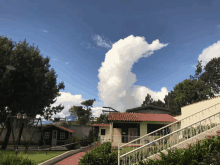 a house with a red tile roof and a cloud in the sky