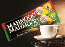 two packets of mahmood coffee with a cup of coffee