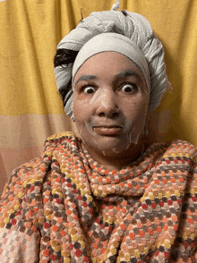 a woman with a towel wrapped around her head and a face mask on