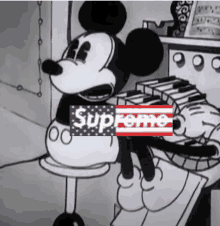 a black and white cartoon of mickey mouse playing a piano with a supreme logo on it