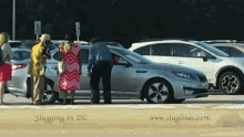 a group of people are standing around a silver car in a parking lot with the words slugging in dc on the bottom