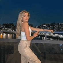 a woman is standing on a balcony overlooking a river .