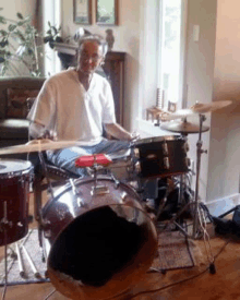 a man is playing drums in a living room in a living room .