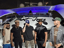 a group of men standing in front of a boat that says all that jazz on it