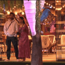 a man and a woman standing in front of a restaurant with a sign that says ' apollo ' on it